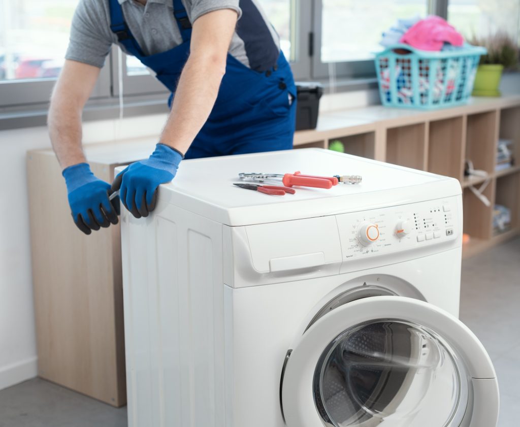 Professional Hilton Appliance repairman fixing a Panasonic washer